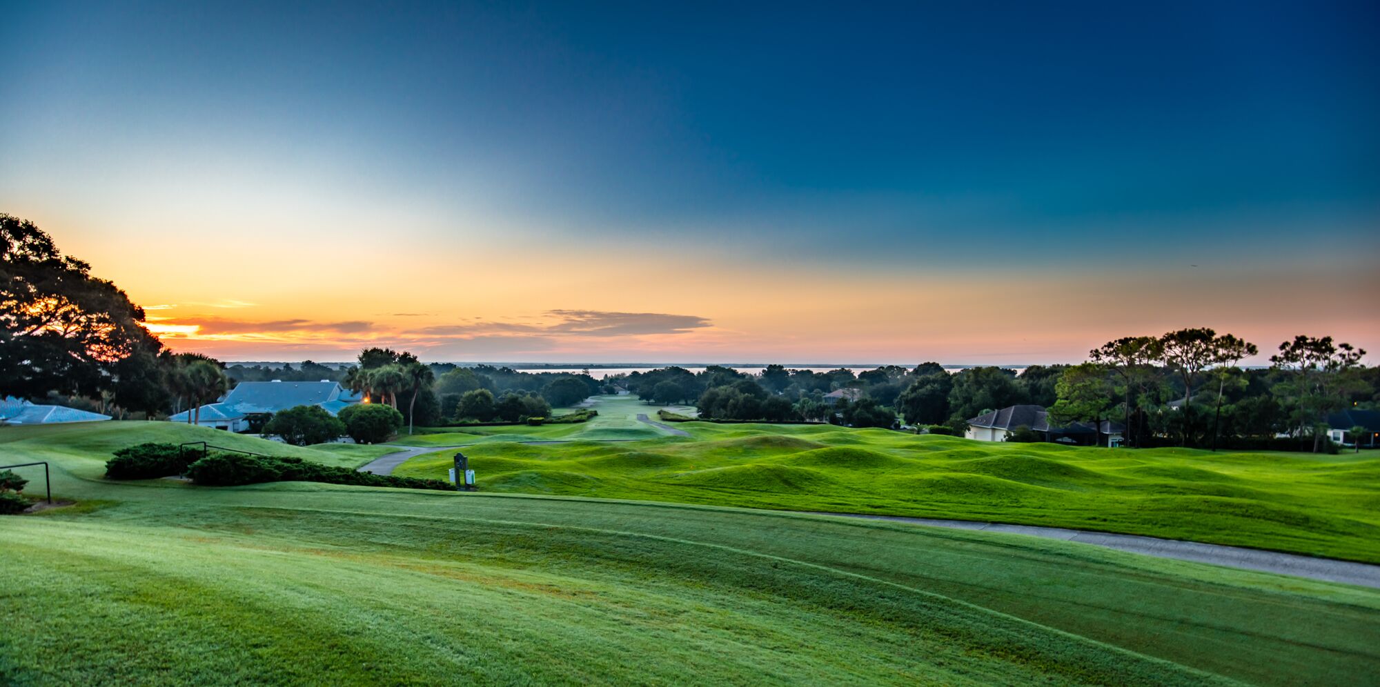 Golf course ground with a stunning blue sky during the evening, offering a serene and peaceful atmosphere.
